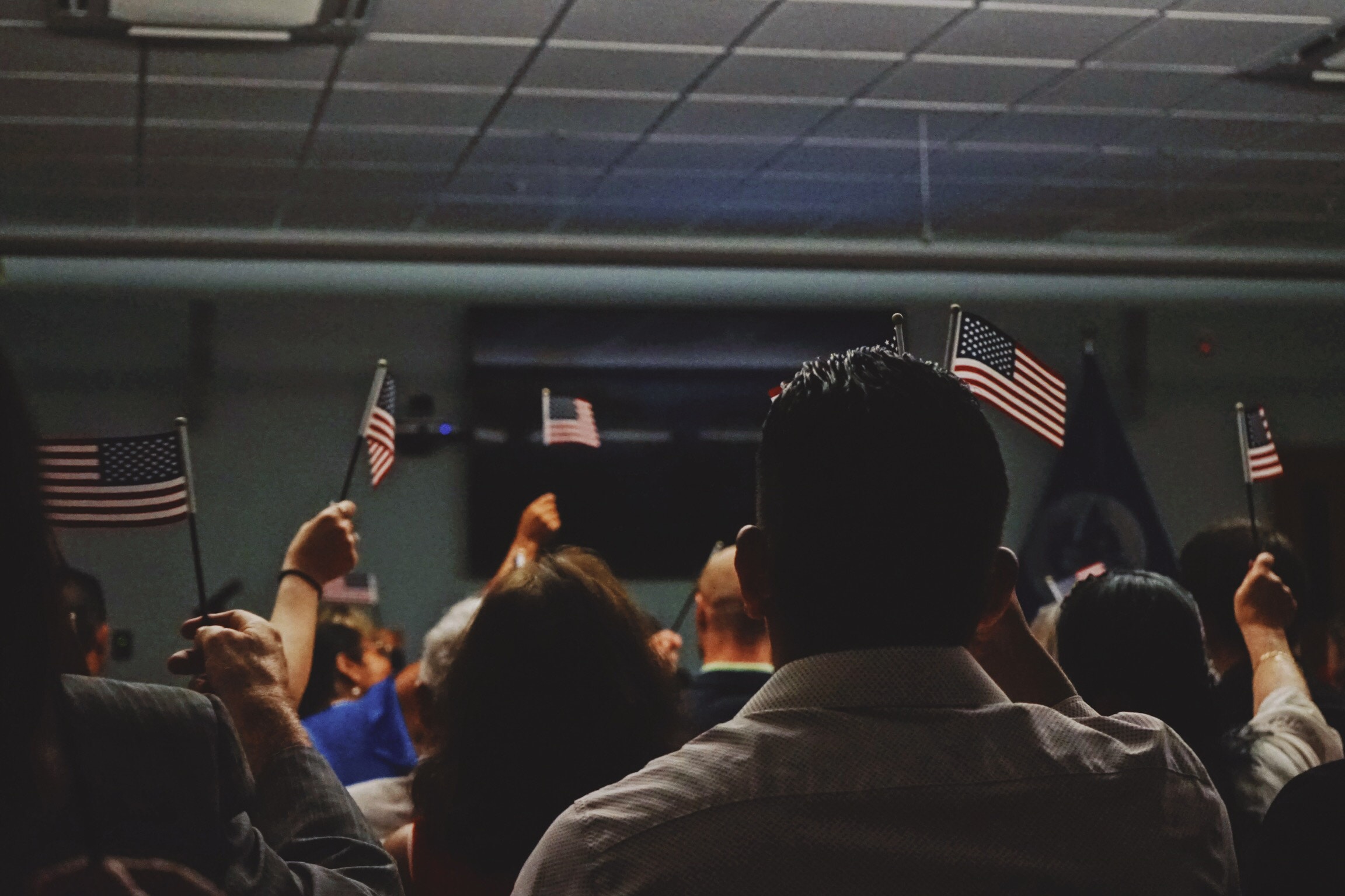 Naturalization ceremony with people waving flags